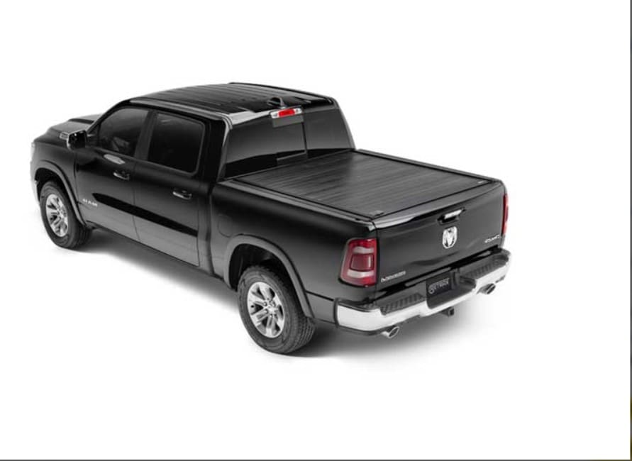 A black truck with its bed up and the lid open.